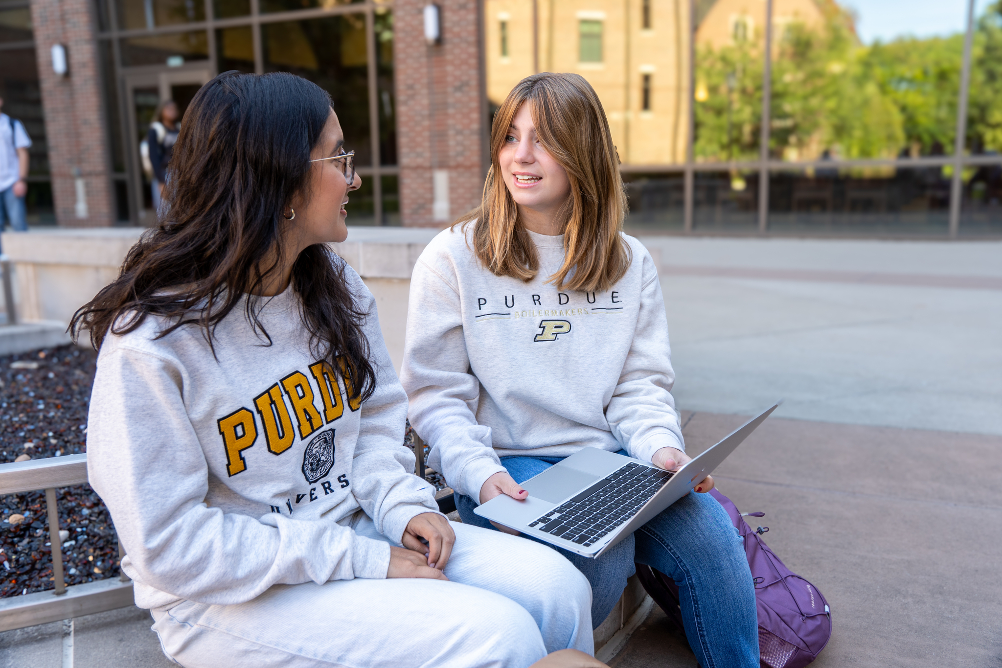 One student showing another student something on their laptop